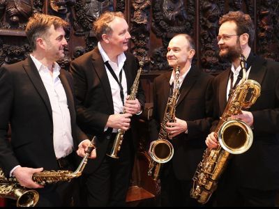 Quartz Saxophone Quartet in suits smiling at each other